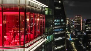 Panoramic view of the Sky Bar at the Ritz-Carlton, featuring a stylish, modern rooftop setting with elegant seating, ambient lighting, and a breathtaking city skyline backdrop