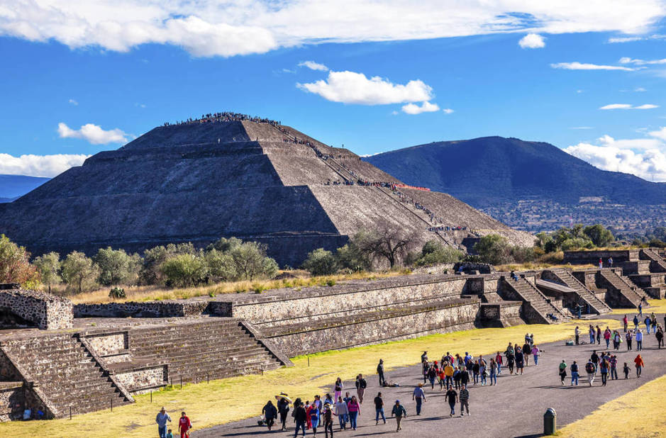 View of the Pyramid of the Sun at the Teotihuacan archaeological site, with visitors exploring the ancient ruins