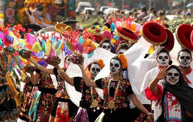 People dressed in traditional costumes at a Dia de los Muertos celebration.