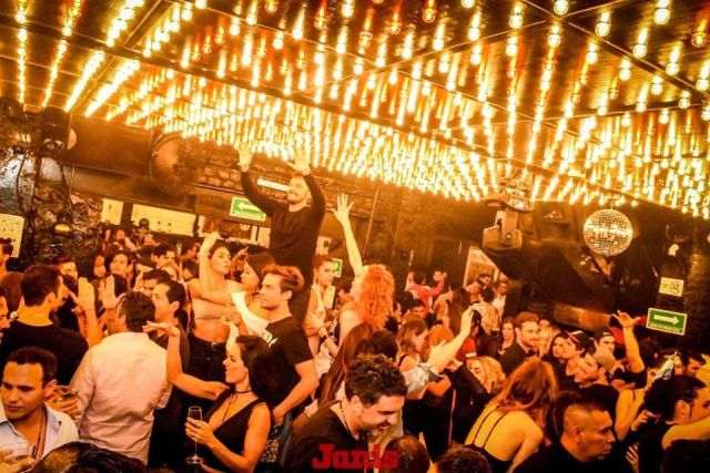 People dancing on a crowded nightclub dance floor.