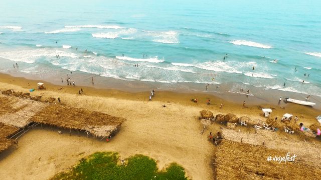 Aerial view of Tecolutla Beach with people enjoying the shore and water.